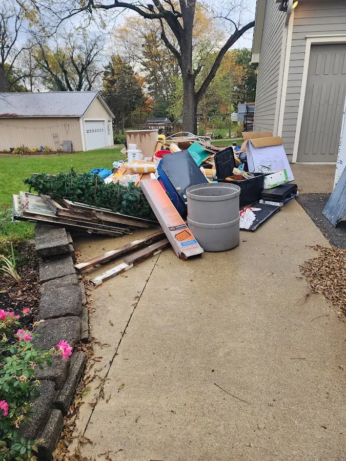 Dumpster being loaded with debris for Estate Cleanout Dumpster Rental in Greendale